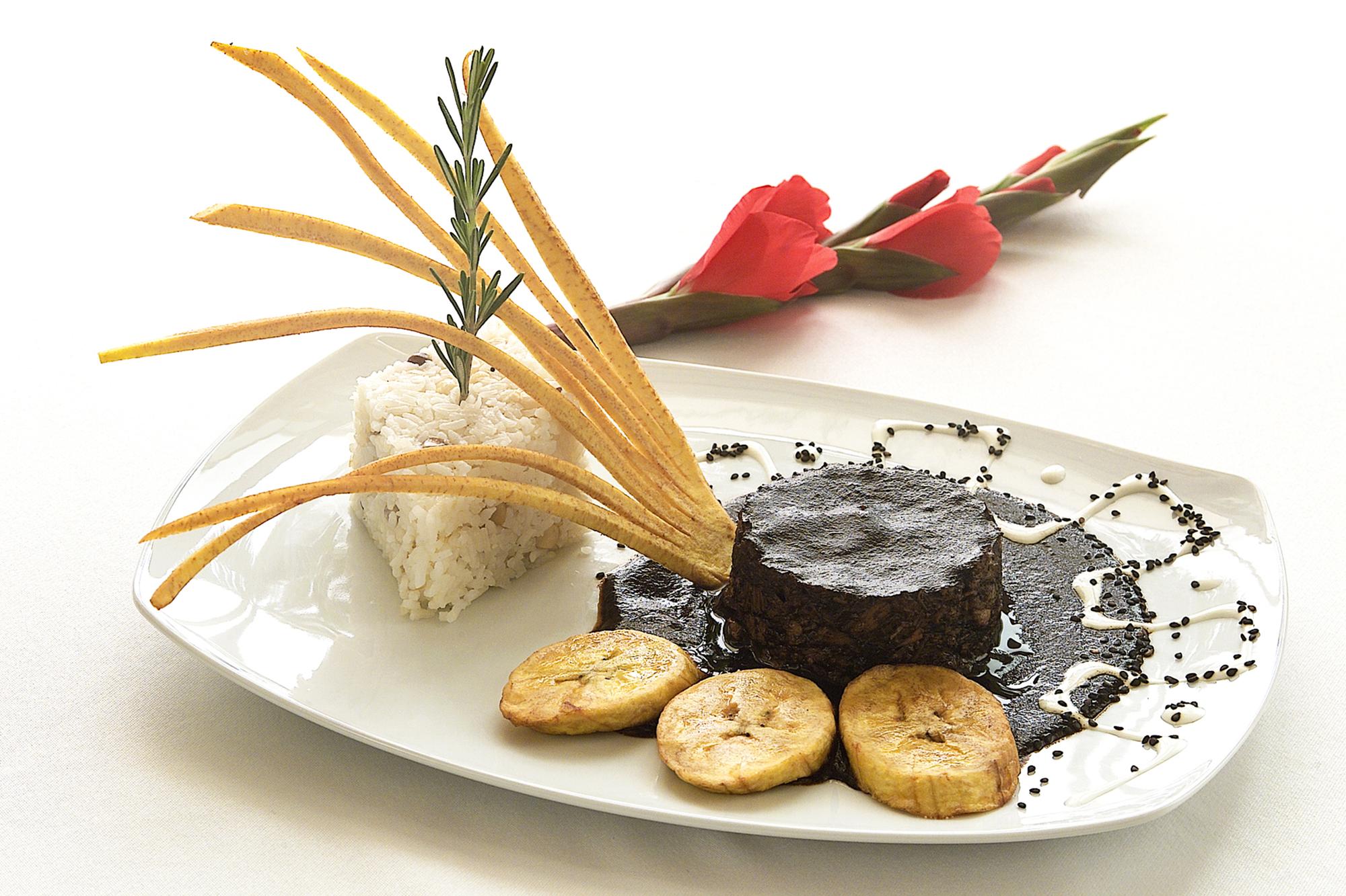 Three plated signature dishes on black slate